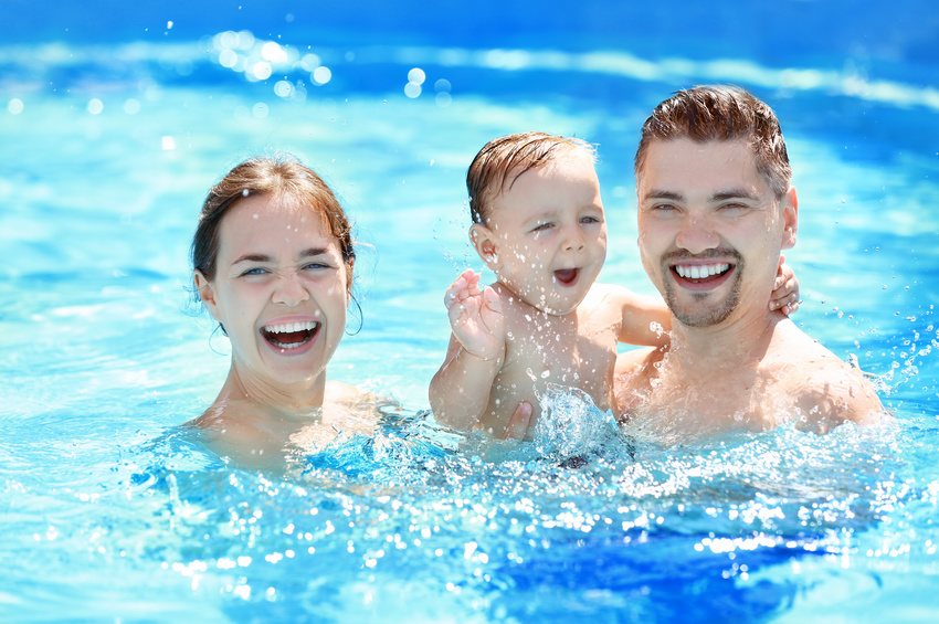 Child swimming lesson. Cute little boy learning to swim with parents in pool